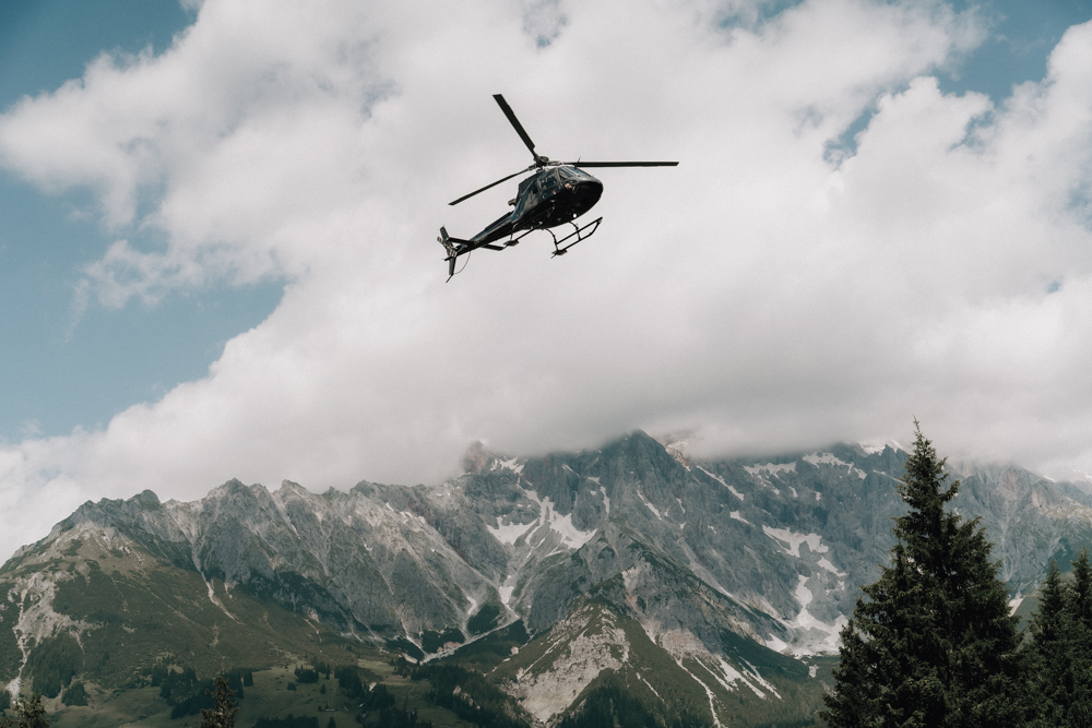 Hubschrauber mit Braut im Anflug auf die Hochzeitslocation Deantnerin vor der Bergkulisse des Hochkönigs