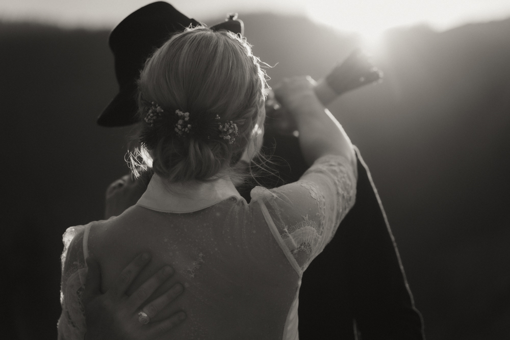 Romantische Umarmung des Brautpaars im Sonnenuntergang bei ihrer Hochzeit in der Deantnerin
