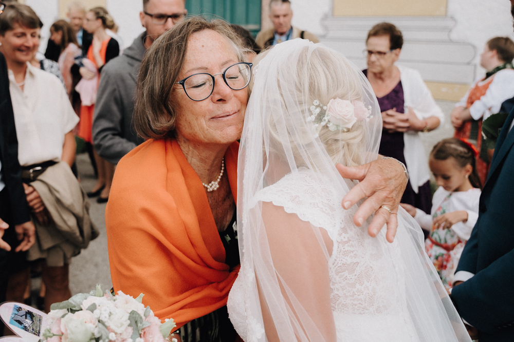 Emotionale Umarmung nach der Trauung – Braut wird von einer Hochzeitsgästin bei der Hochzeit im Pitzlloch herzlich begrüßt.