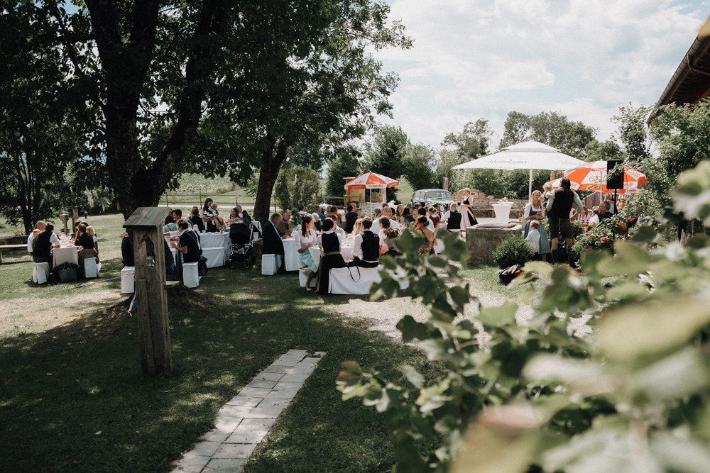 Hochzeit im Pitzlloch bei Traunstein – Gäste feiern im idyllischen Garten unter strahlendem Sonnenschein.