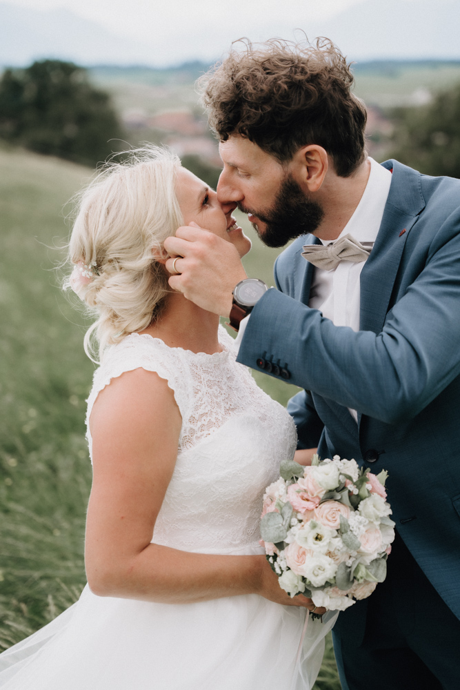 Brautpaar beim Kuss auf einer Wiese – Liebevolle Pärchenaufnahme bei der Hochzeit im Pitzlloch.