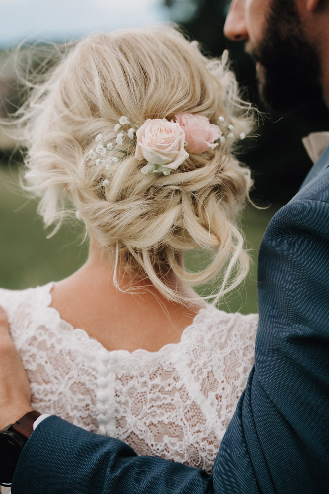 Detailaufnahme der Brautfrisur mit Blumenkranz bei der Hochzeit im Pitzlloch – Romantischer Moment mit Bräutigam.