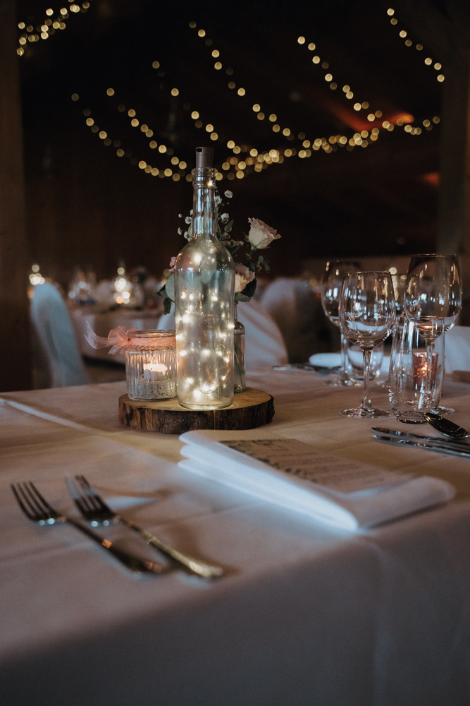 Stimmungsvolle Tischdekoration bei der Hochzeit im Pitzlloch – Beleuchtung mit Lichterketten und Kerzen.